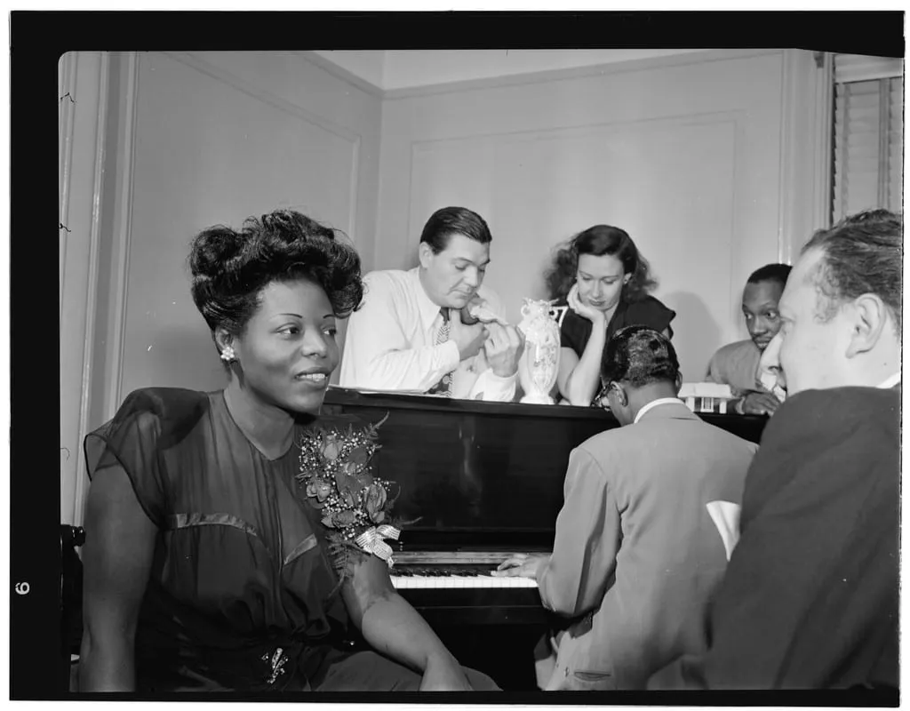 Archive image: Gottlieb, William P., 1917-, photographer. [Portrait of Dizzy Gillespie, Mary Lou Williams, Tadd Dameron, Hank Jones, Milt Orent, Dixie Bailey, and Jack Teagarden, Mary Lou Williams' apartment, New York, N.Y., ca. Aug. 1947] 1 negative : b&w ; 3 1/4 x 4 1/4 in. Caption from Down Beat: Mary Lou Willi