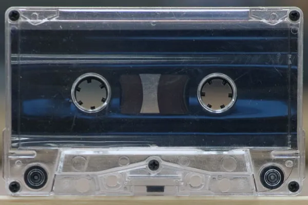 Clear compact audio cassette resting on a plain white surface.