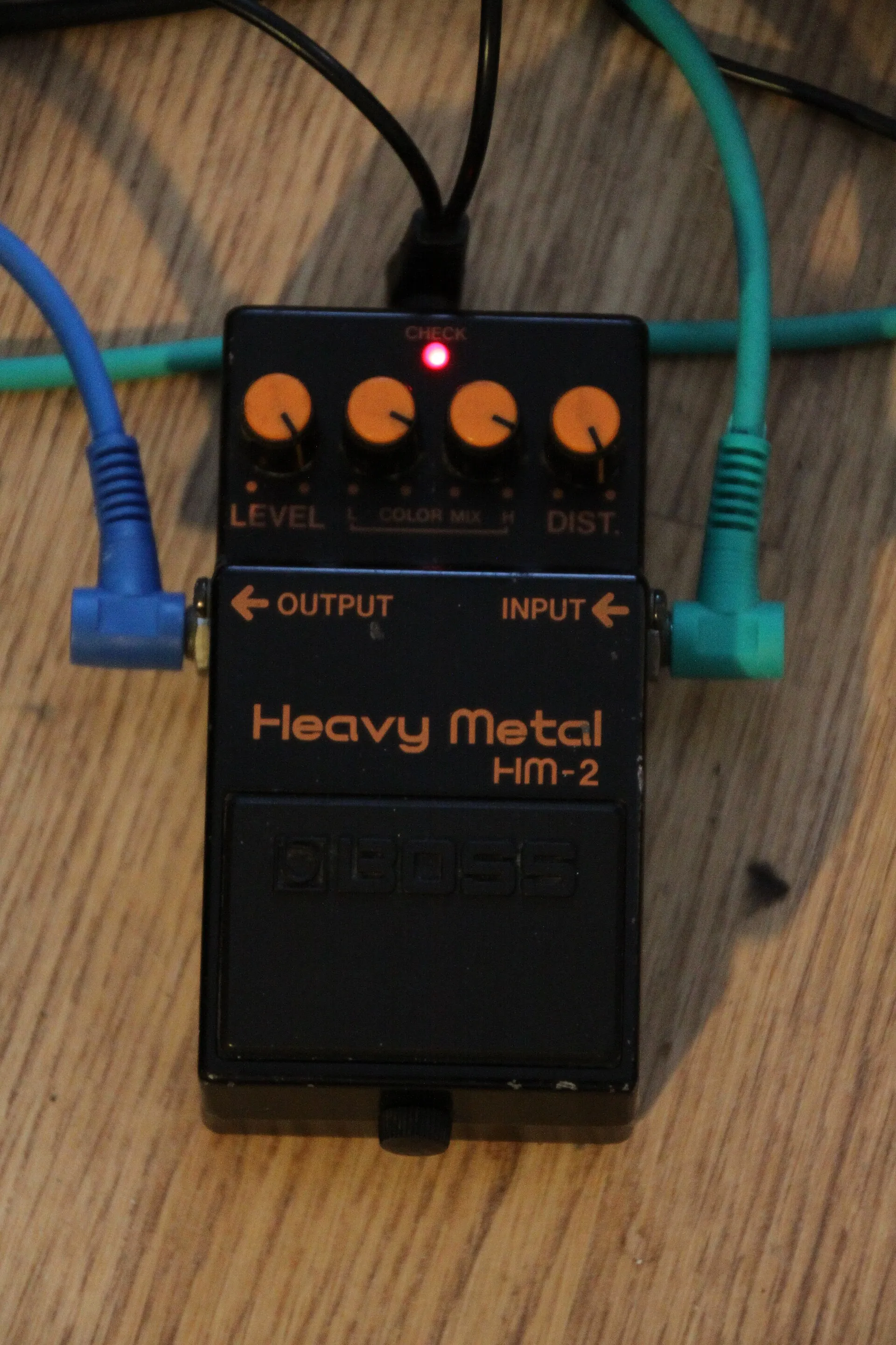 Black BOSS HM-2 Heavy Metal distortion pedal with orange labels and four control knobs photographed against a plain background.