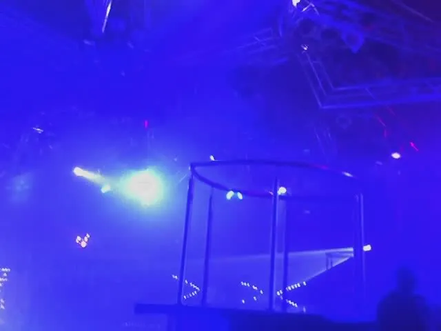 Blue stage lights and haze above a dark indoor discotheque floor.