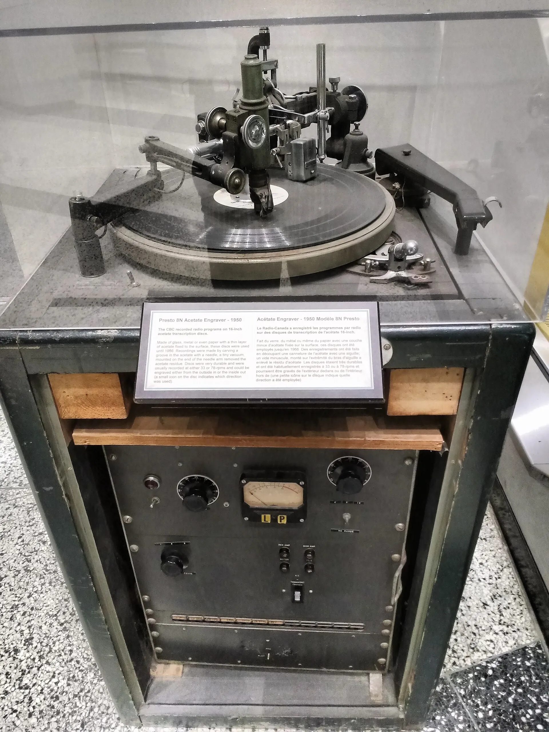 Vintage Presto disc-cutting machine with a platter, cutting head, control panel, and metal arm mounted in a cabinet.