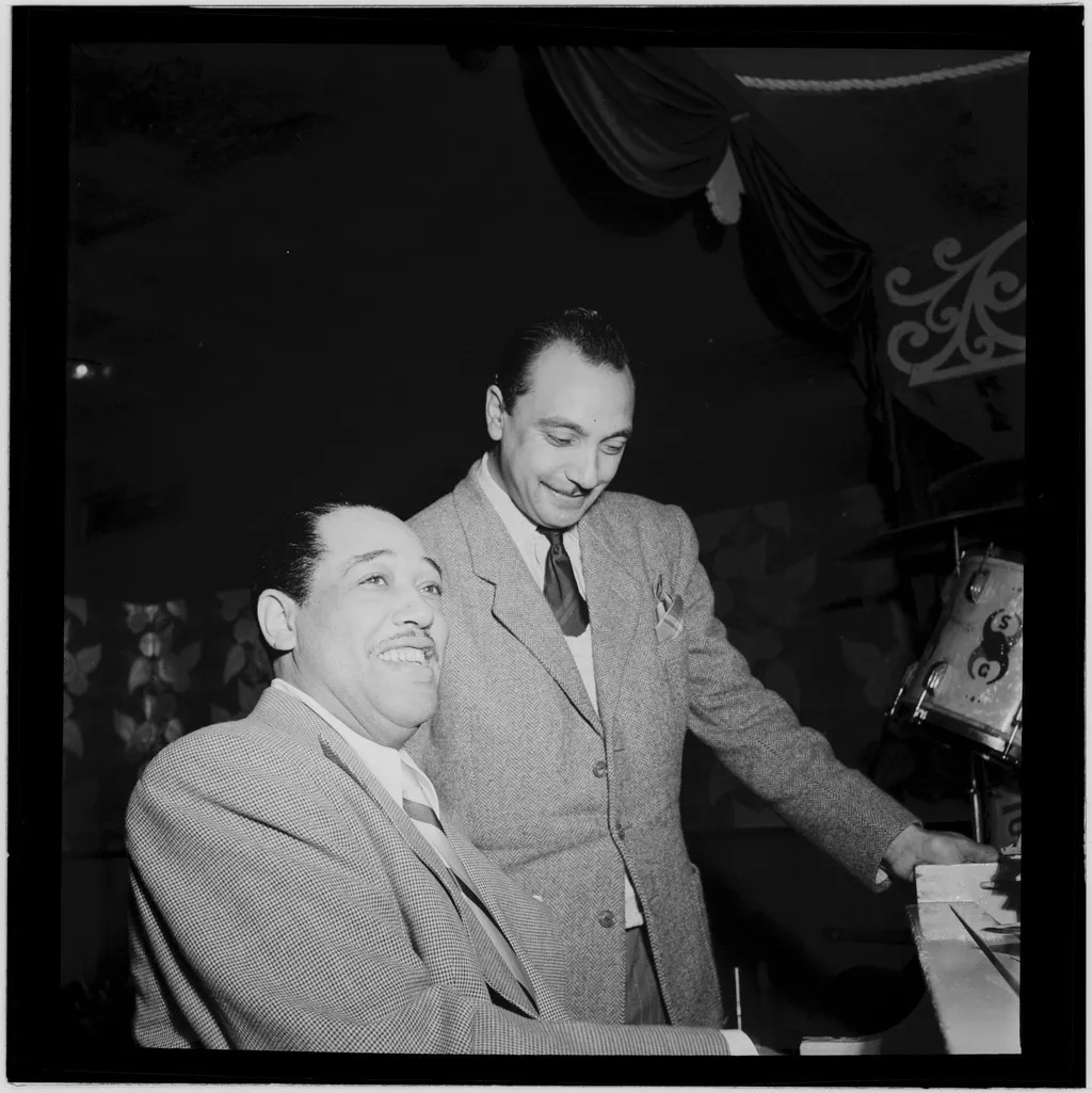 Black-and-white photograph of Django Reinhardt and Duke Ellington standing side by side backstage at the Aquarium in New York in 1946.
