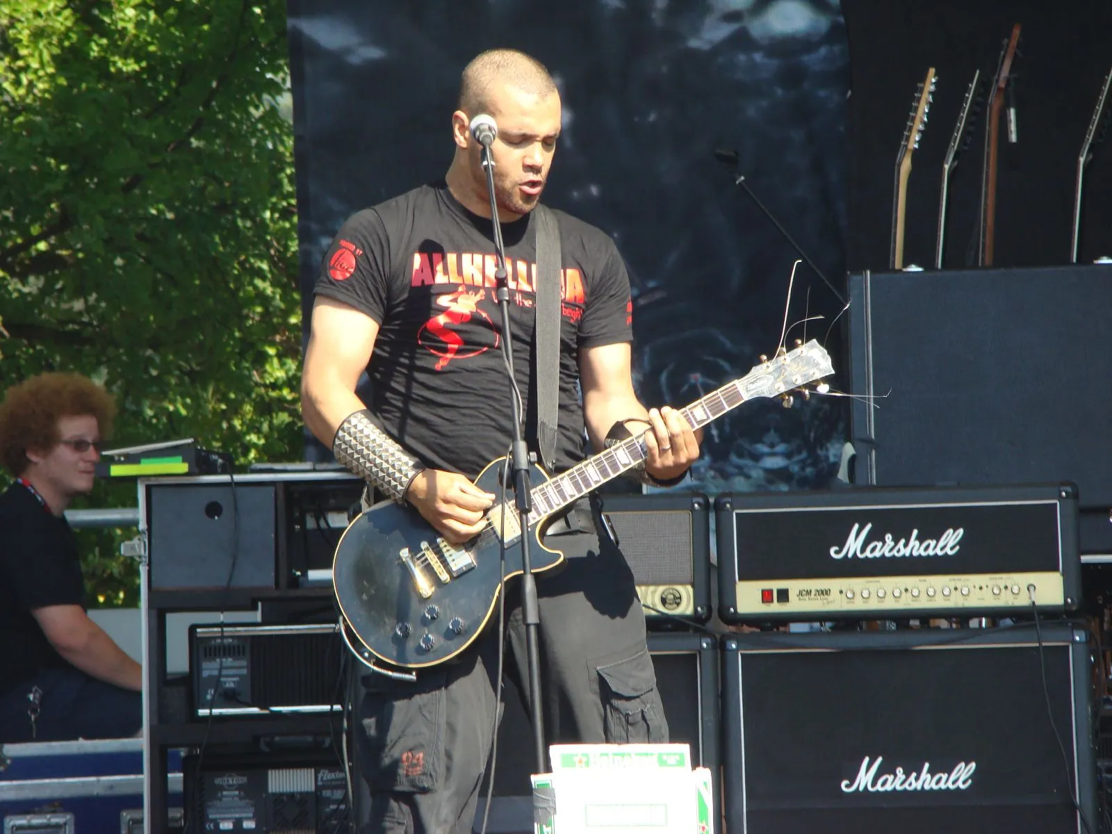 An Entombed guitarist plays a dark electric guitar under blue stage light at Frozen Rock Festival in 2007.