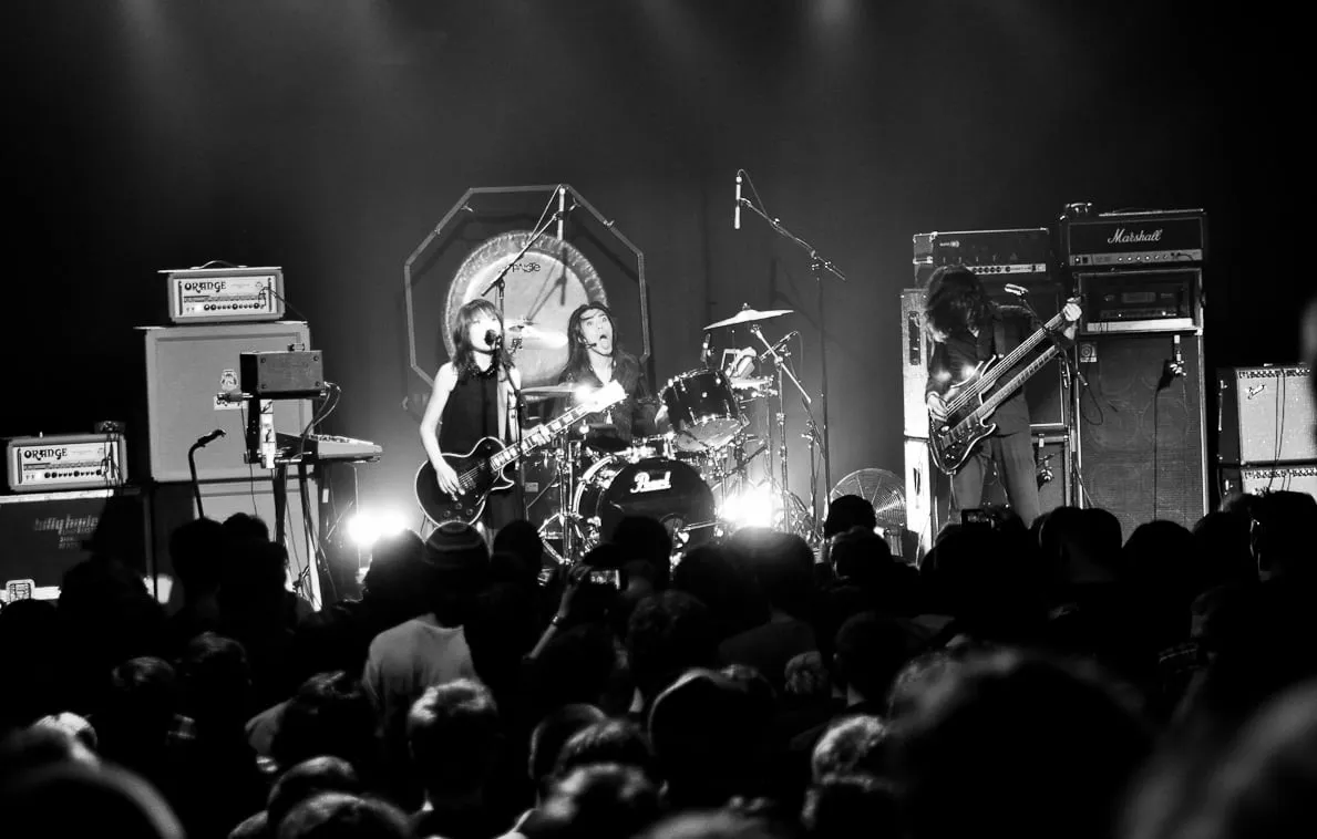 Boris performing live in Australia in 2012, with guitar, drums, smoke, and amber stage lights.