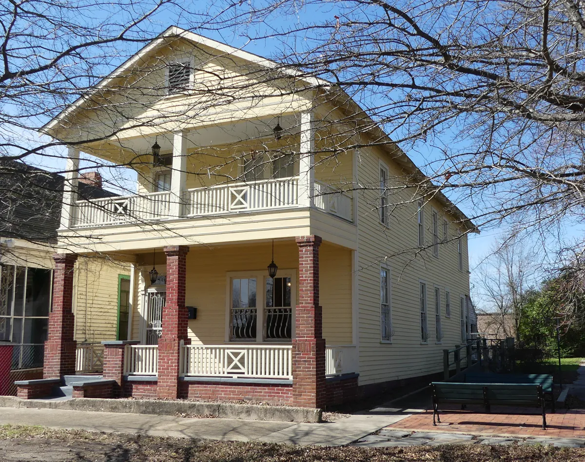 Two-story blue wooden house with a porch, white trim, and a Ma Rainey House sign beside the front steps in Columbus, Georgia.