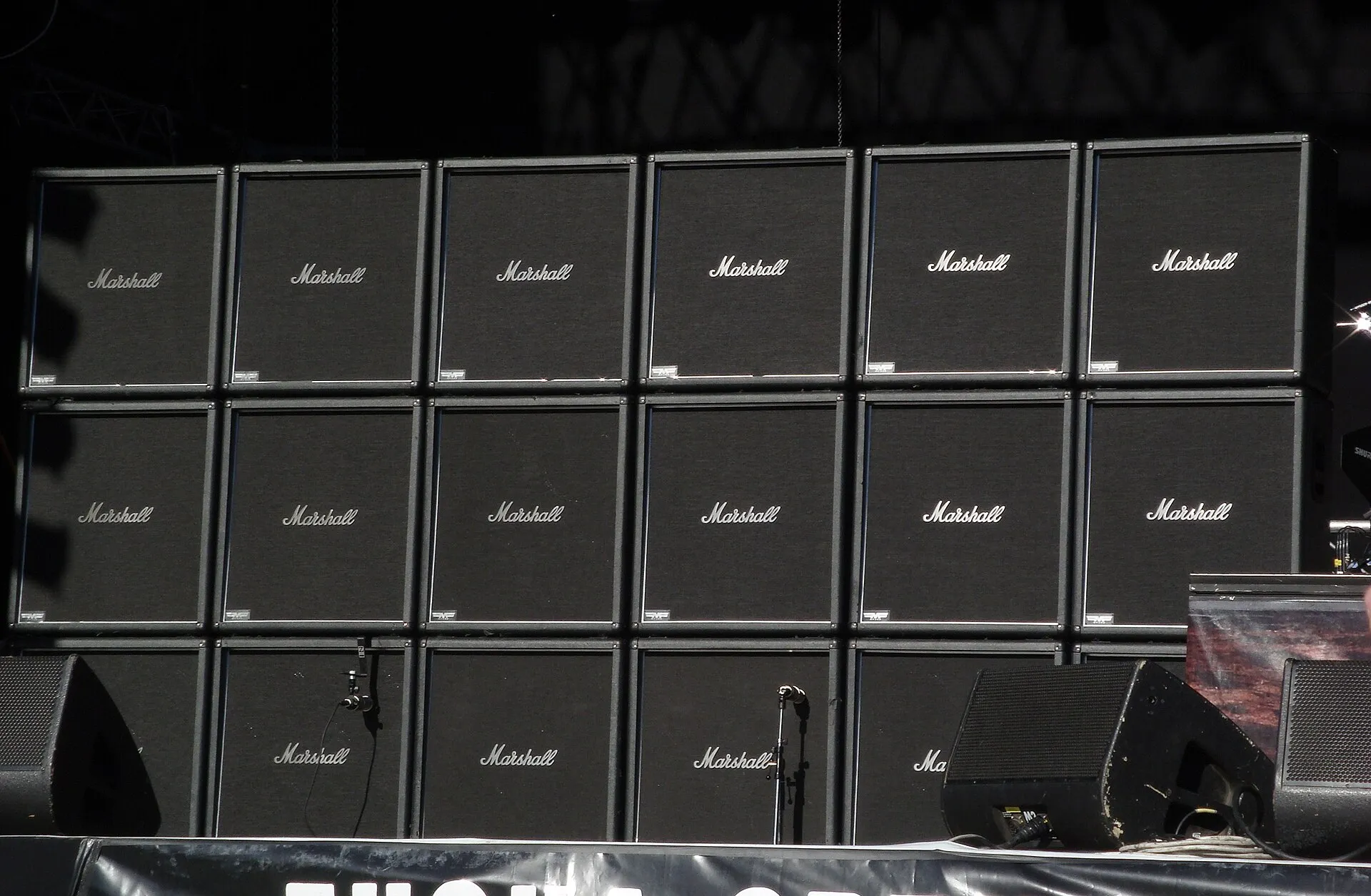 Eighteen black Marshall speaker cabinets form a wide wall across a festival stage before a Slayer performance in 2008.