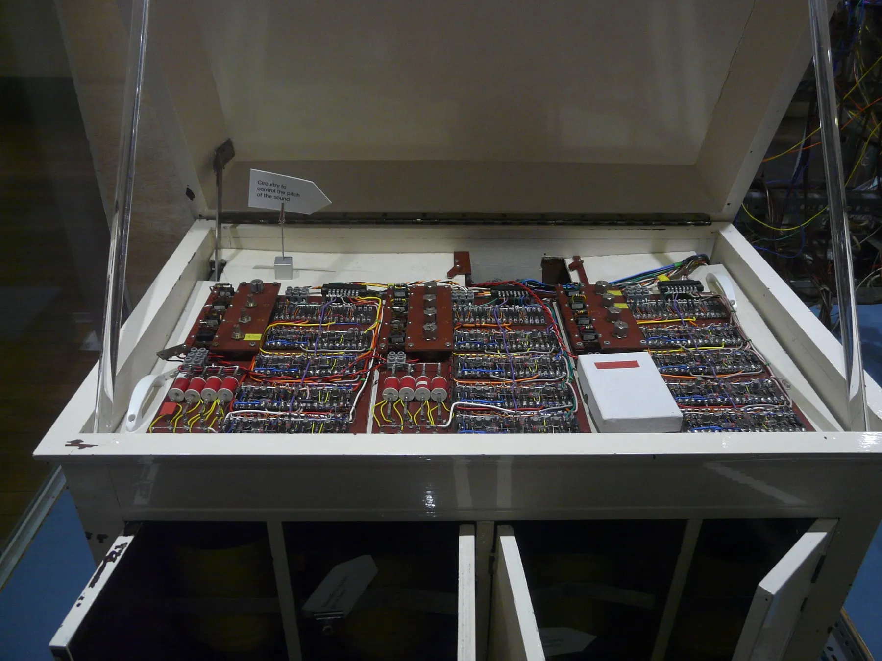 Open cabinet of the Oramics sound generator showing rows of colored circuit boards beneath a dark display hood.