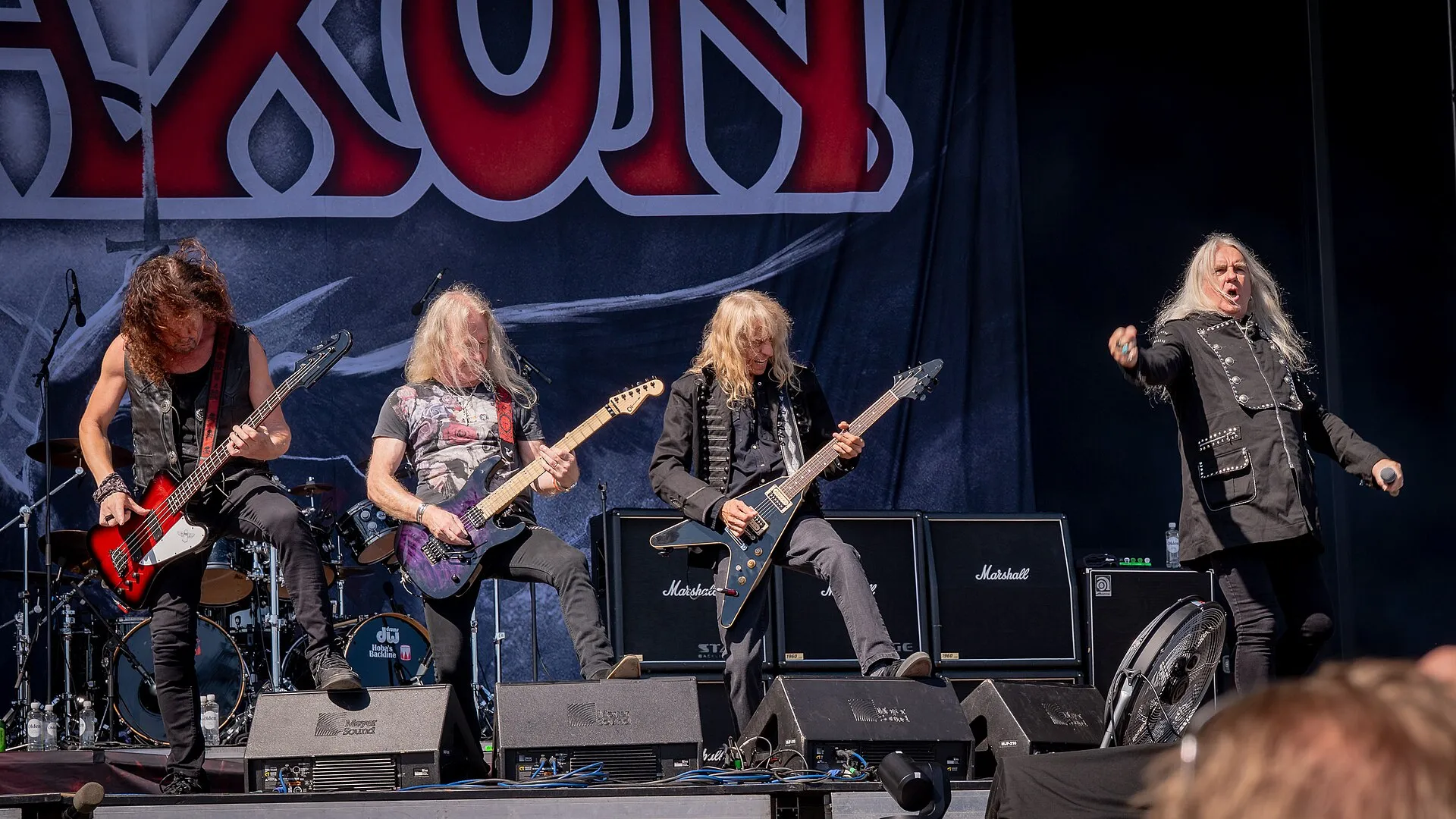 The five members of Saxon pose together outdoors at the Tons of Rock festival in Oslo in 2024.
