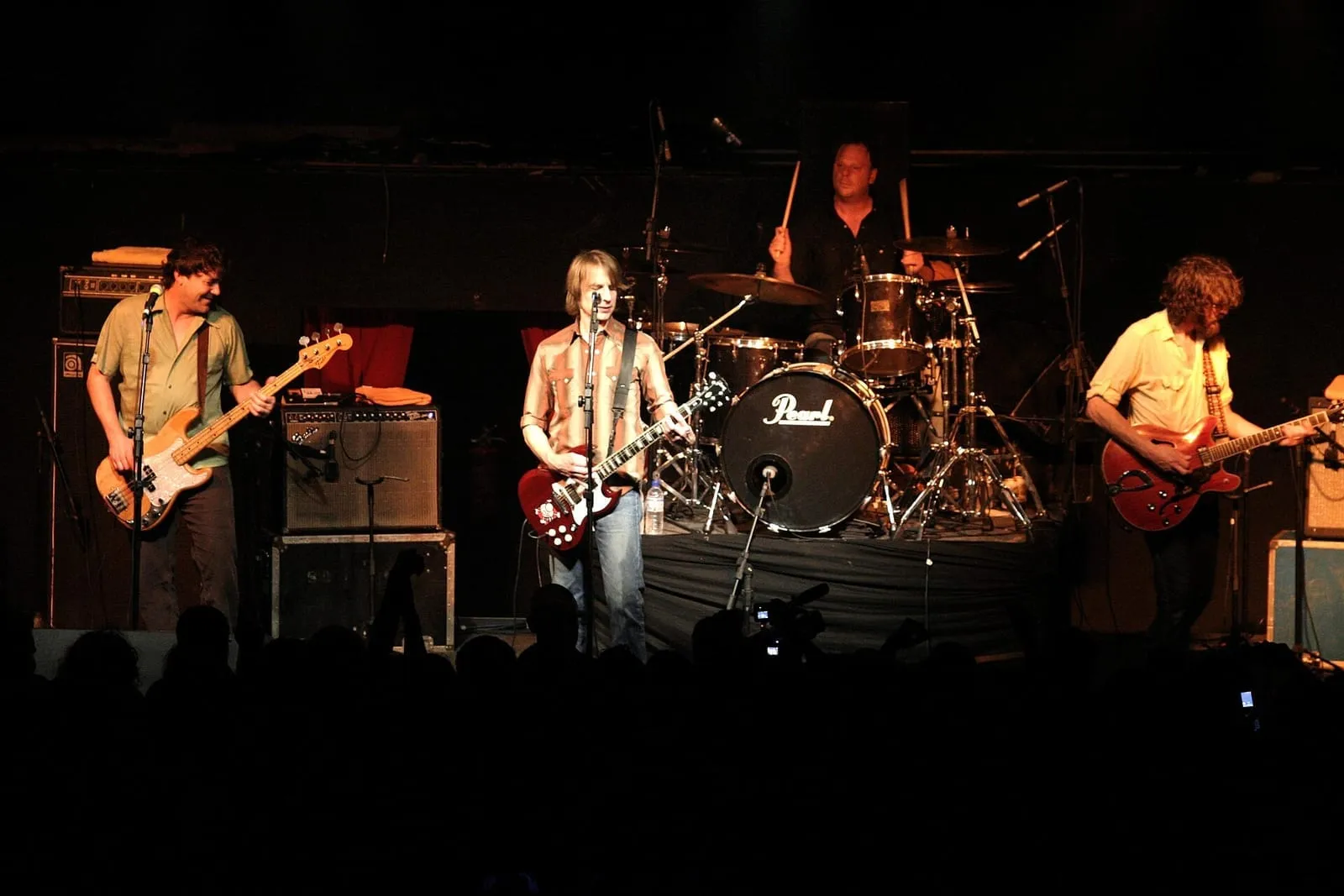 Five members of Mudhoney performing together on a dark concert stage in June 2007.