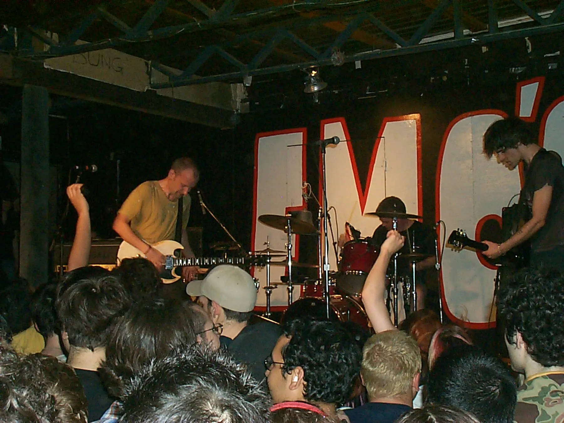 Fugazi performing together on a low stage at Emo's in Austin in March 2002.
